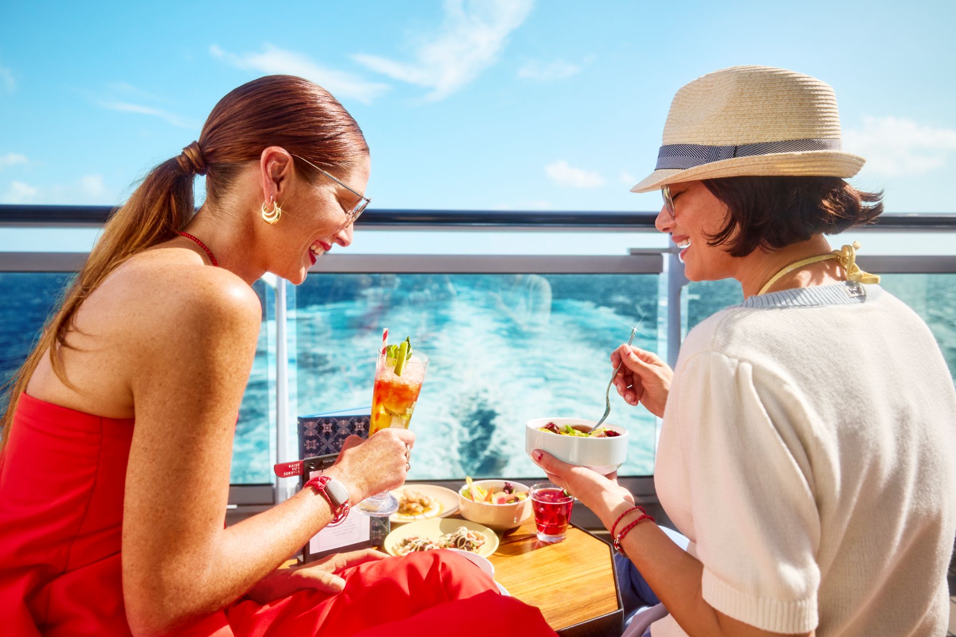 Friends sharing a meal and drinks over the ocean